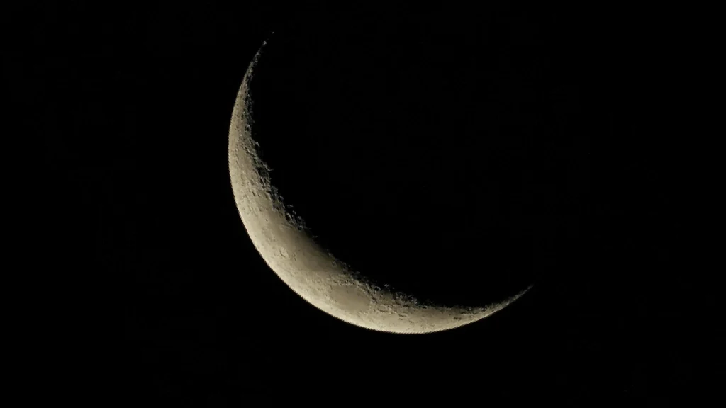 Almost new moon in a dark sky with the text: 'For each end of a cycle, a new beginning